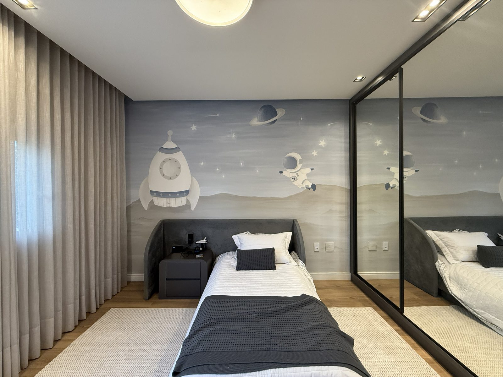Mural espacial com foguete e astronauta em quarto infantil